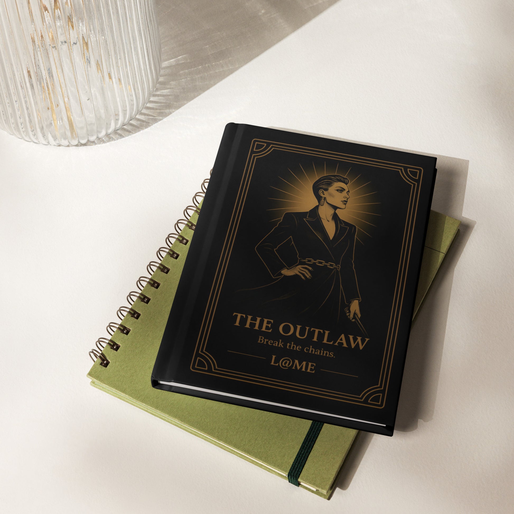 Matte black hardcover journal with gold Outlaw tarot-style artwork and lined pages.